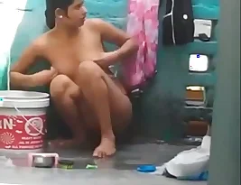 An man records his girlfriend, a college student, while she takes a bath in the outdoors.